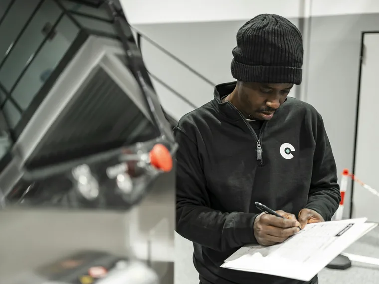 Worker filling in a form on a clipboard