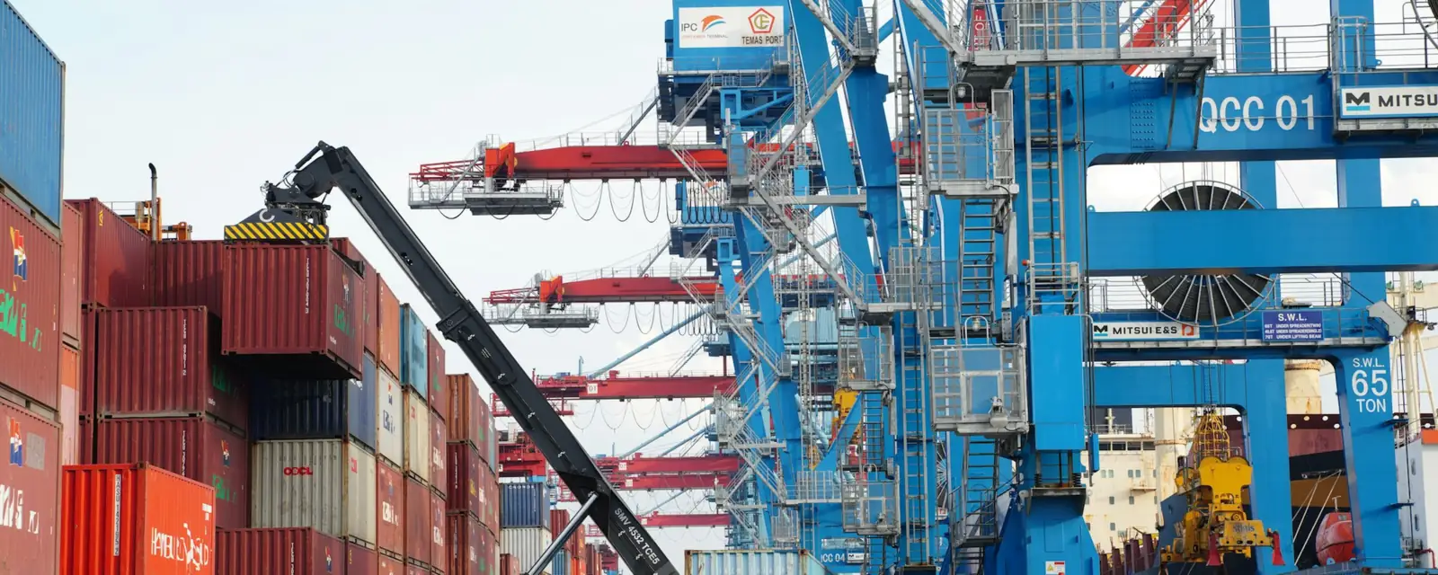 Container terminal with gantry cranes and a reach stacker moving a container