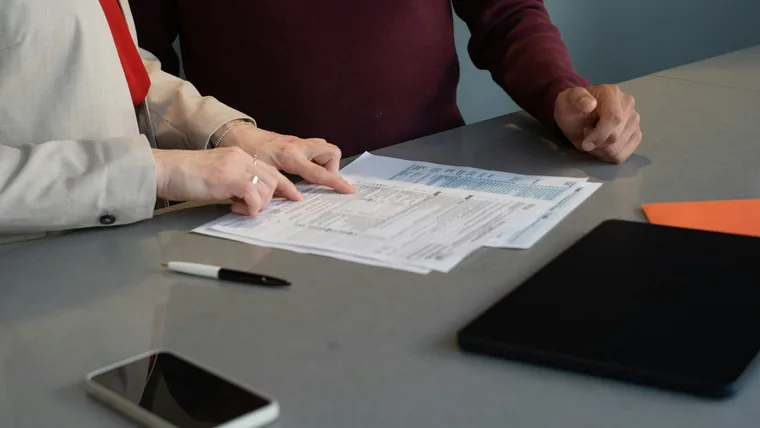 Two people reviewing printed documents at a table
