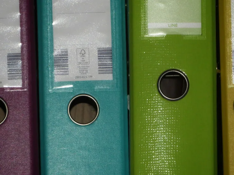 Row of ring binders in purple, teal and green