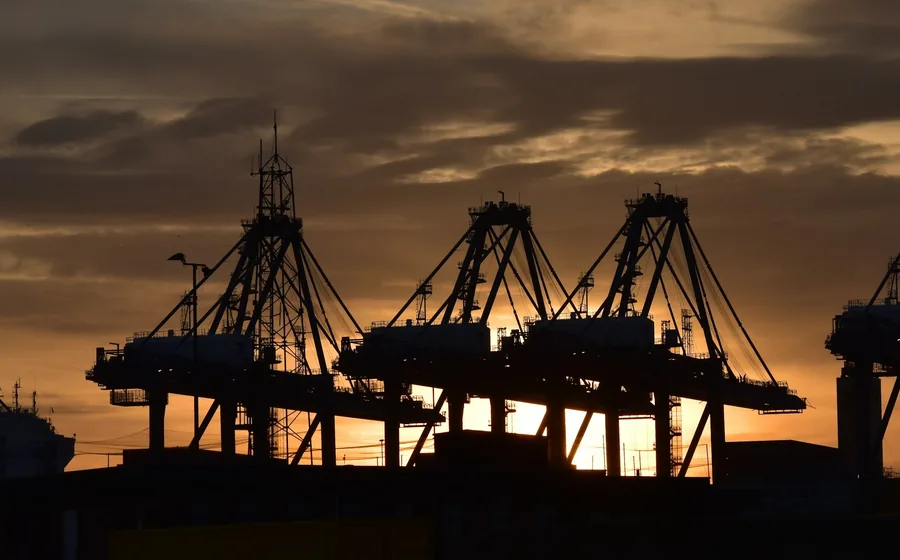 Container cranes silhouetted at sunset