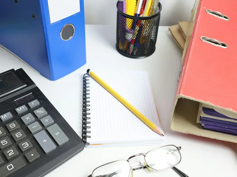 Office binders, a calculator and a notebook on a desk