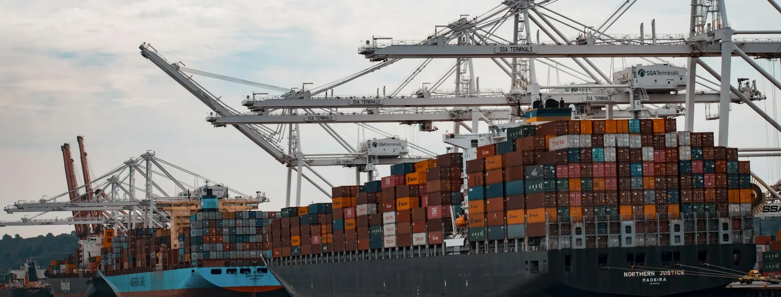 Loaded container ship at a quay under gantry cranes