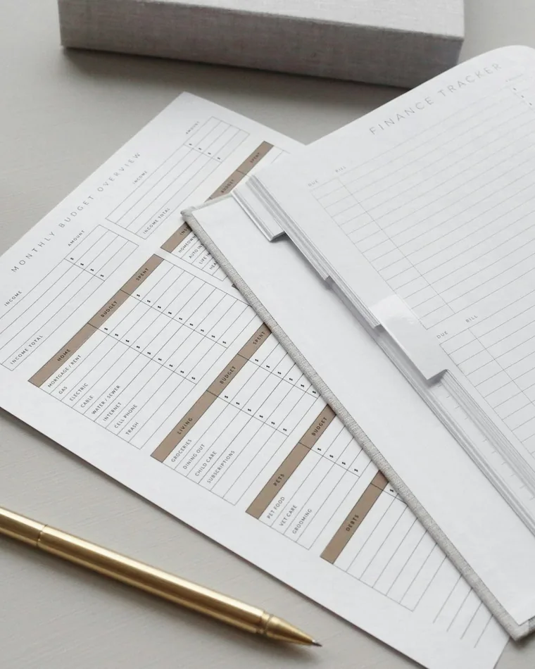 Budget planner sheets with a gold pen and paper clips