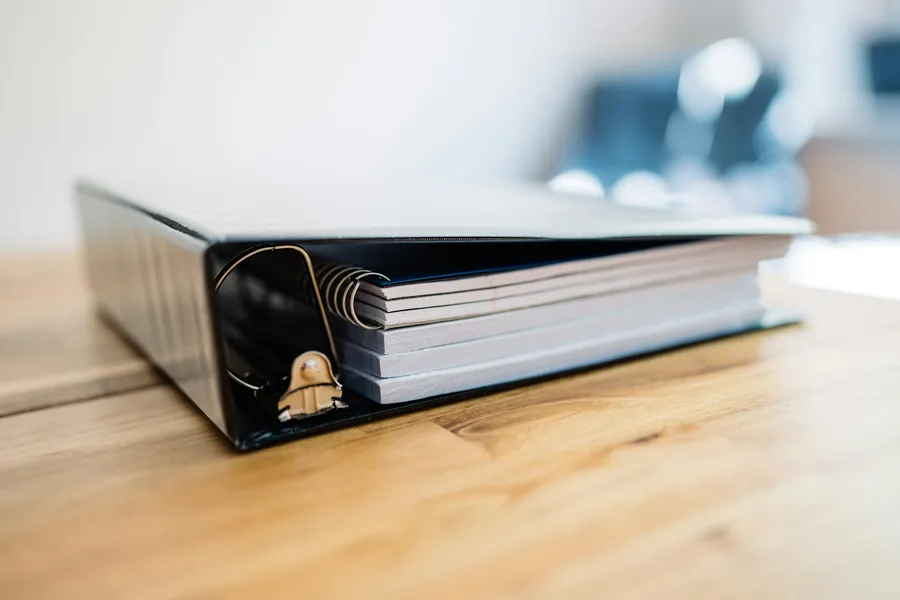 Ring binder of documents on a wooden desk
