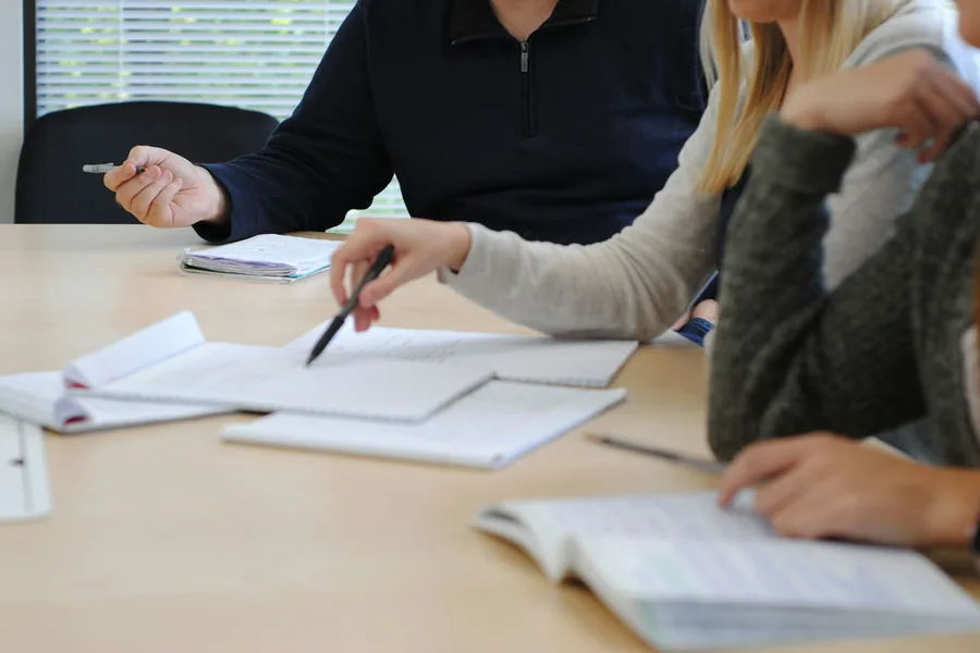 People reviewing papers and notes at a meeting table