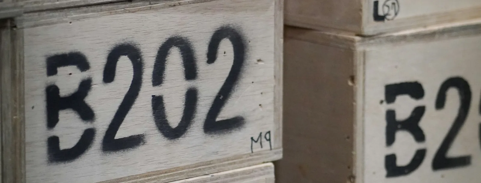Stacked wooden crates stencilled with the code B202