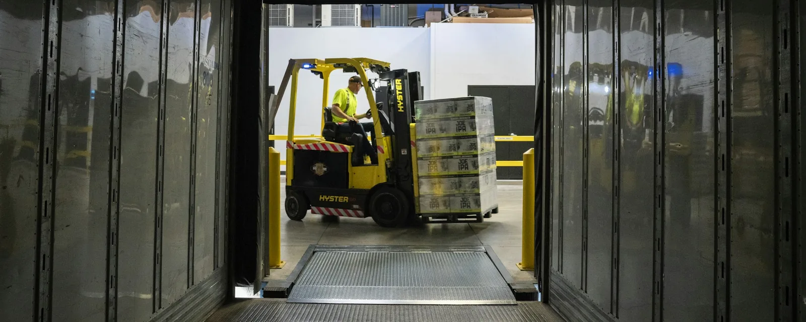 Forklift loading pallets into a shipping container
