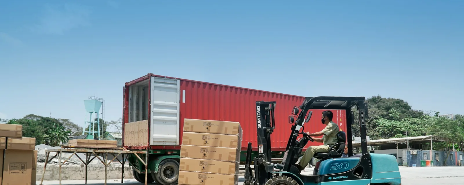 Forklift loading boxes into a shipping container