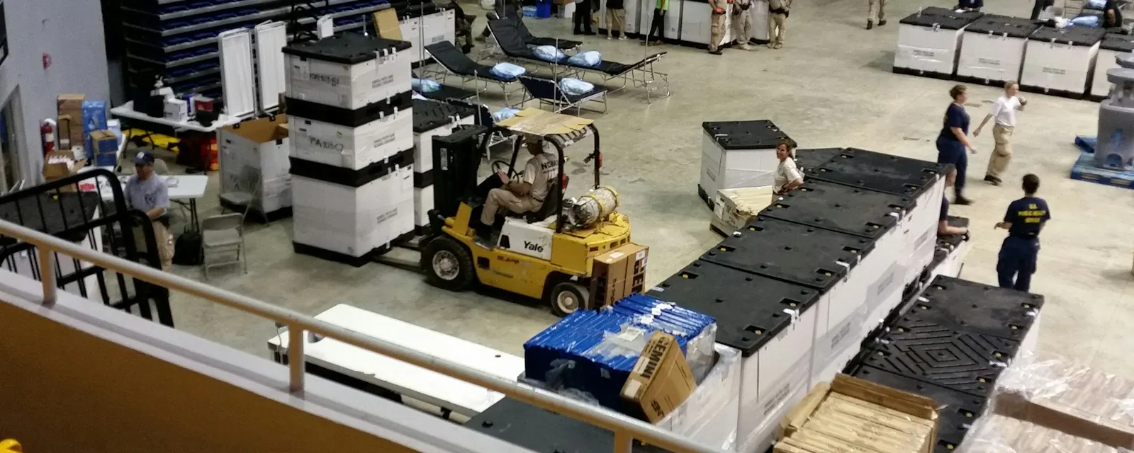 Warehouse floor with a forklift, workers and stacked crates